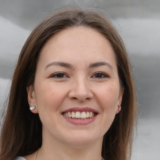 Joyful white young-adult female with long  brown hair and brown eyes