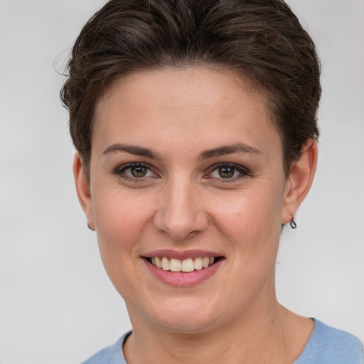 Joyful white young-adult female with short  brown hair and grey eyes