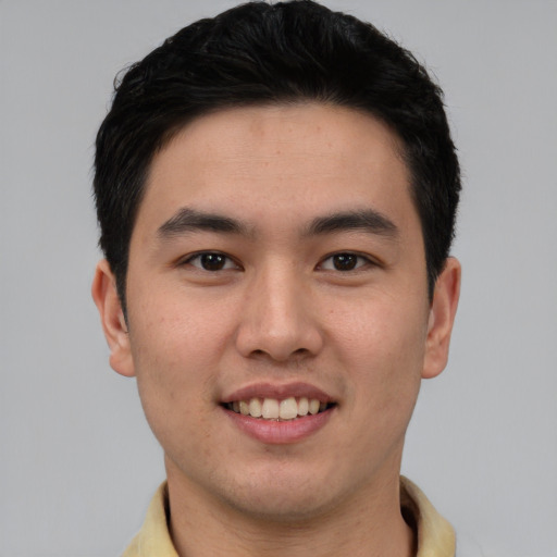 Joyful asian young-adult male with short  black hair and brown eyes