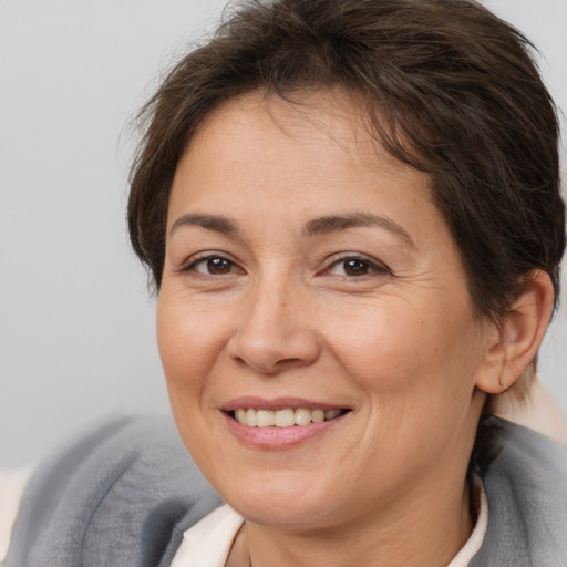 Joyful white adult female with short  brown hair and brown eyes