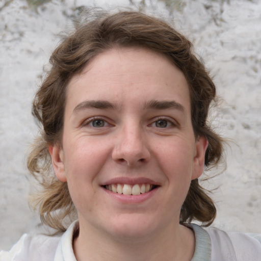 Joyful white young-adult female with medium  brown hair and blue eyes