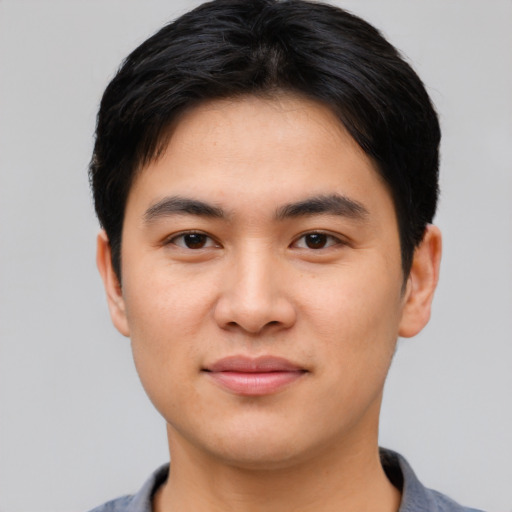Joyful asian young-adult male with short  black hair and brown eyes