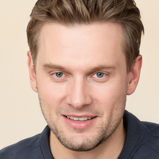 Joyful white adult male with short  brown hair and blue eyes