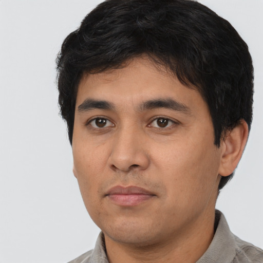 Joyful latino young-adult male with short  black hair and brown eyes