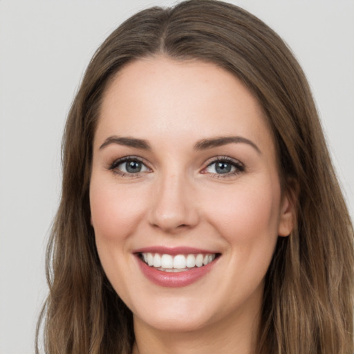 Joyful white young-adult female with long  brown hair and grey eyes