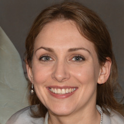 Joyful white adult female with medium  brown hair and blue eyes