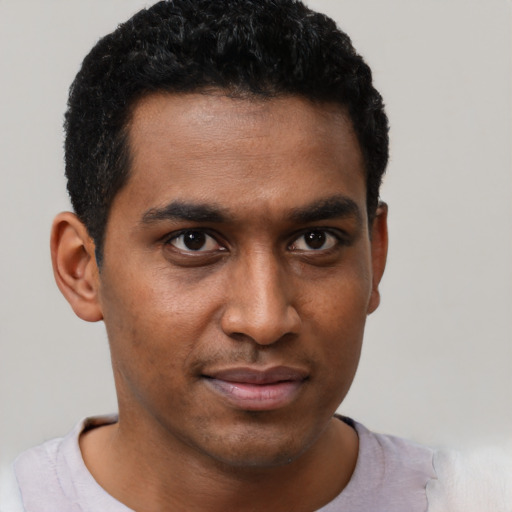 Joyful black young-adult male with short  brown hair and brown eyes