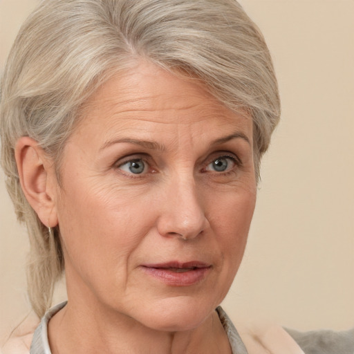 Joyful white middle-aged female with medium  blond hair and grey eyes