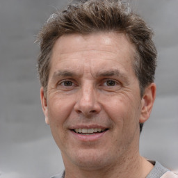 Joyful white adult male with short  brown hair and grey eyes