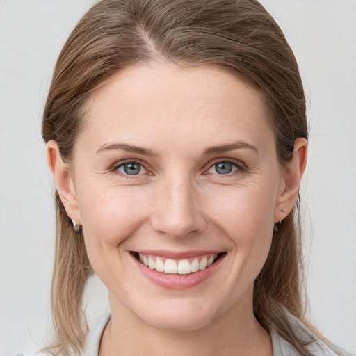 Joyful white young-adult female with medium  brown hair and grey eyes