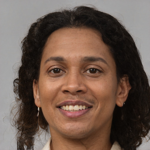 Joyful latino adult female with long  brown hair and brown eyes