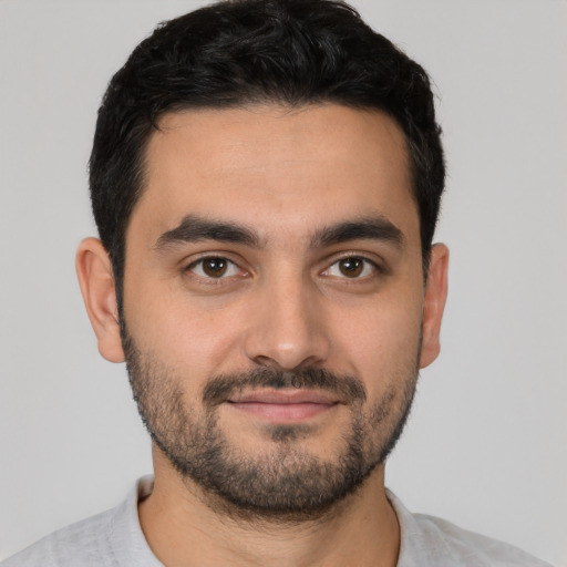 Joyful white young-adult male with short  black hair and brown eyes