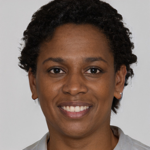 Joyful black young-adult female with short  brown hair and brown eyes