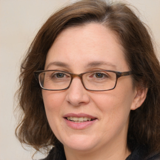 Joyful white adult female with medium  brown hair and grey eyes