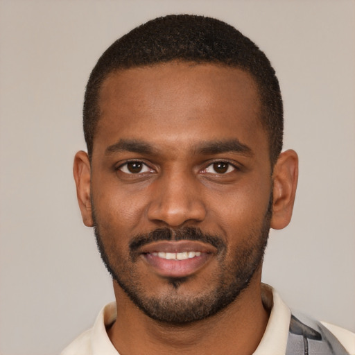 Joyful black young-adult male with short  black hair and brown eyes