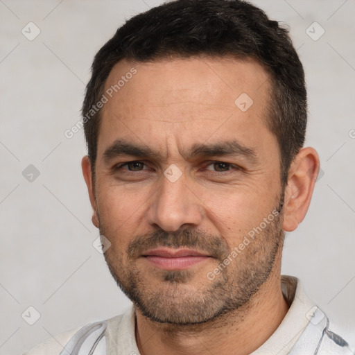 Joyful white adult male with short  black hair and brown eyes