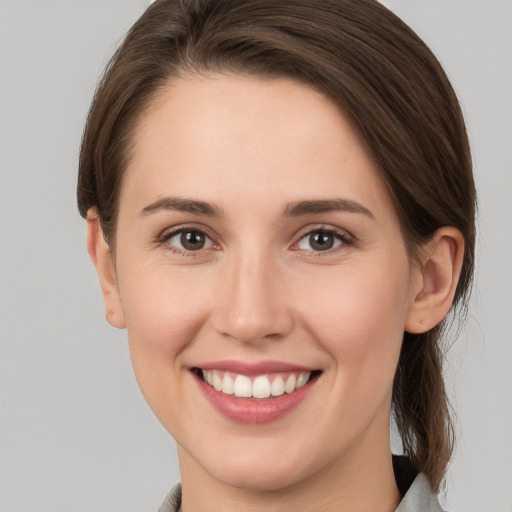 Joyful white young-adult female with medium  brown hair and grey eyes