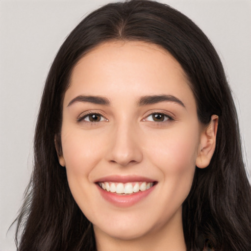 Joyful white young-adult female with long  black hair and brown eyes