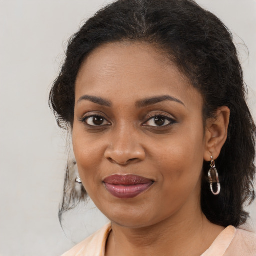 Joyful black young-adult female with medium  brown hair and brown eyes