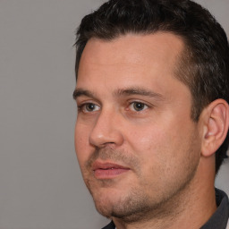 Joyful white adult male with short  brown hair and brown eyes