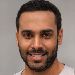 Joyful white young-adult male with short  black hair and brown eyes