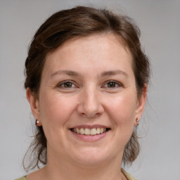 Joyful white adult female with medium  brown hair and grey eyes