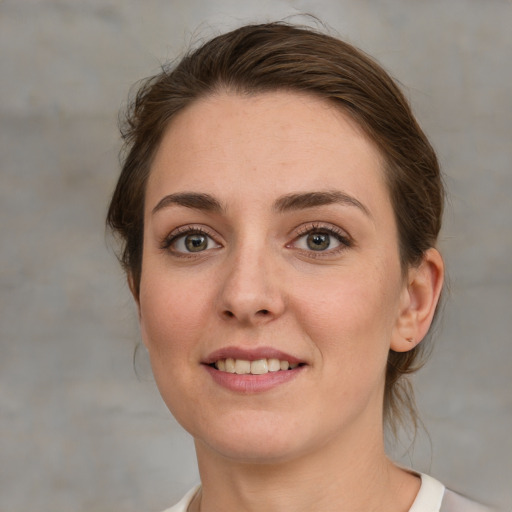 Joyful white young-adult female with medium  brown hair and grey eyes