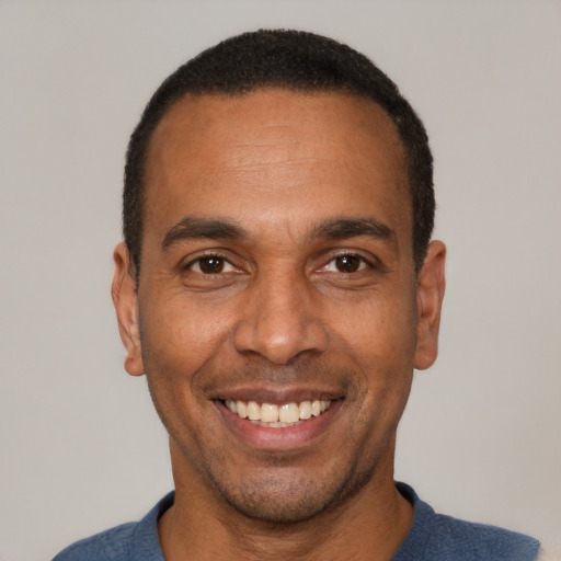 Joyful latino adult male with short  black hair and brown eyes