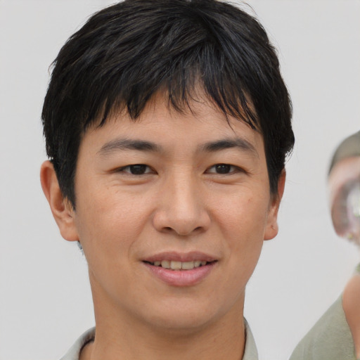 Joyful asian young-adult male with short  brown hair and brown eyes