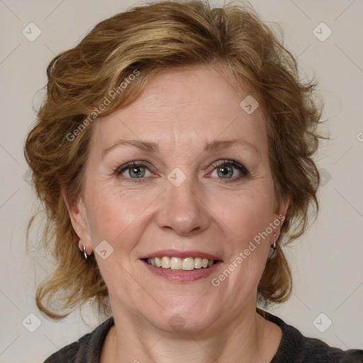 Joyful white adult female with medium  brown hair and blue eyes