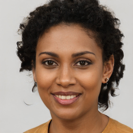 Joyful black young-adult female with medium  brown hair and brown eyes