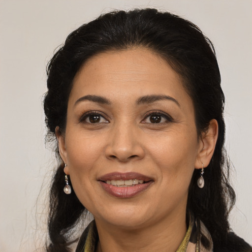 Joyful latino adult female with long  brown hair and brown eyes