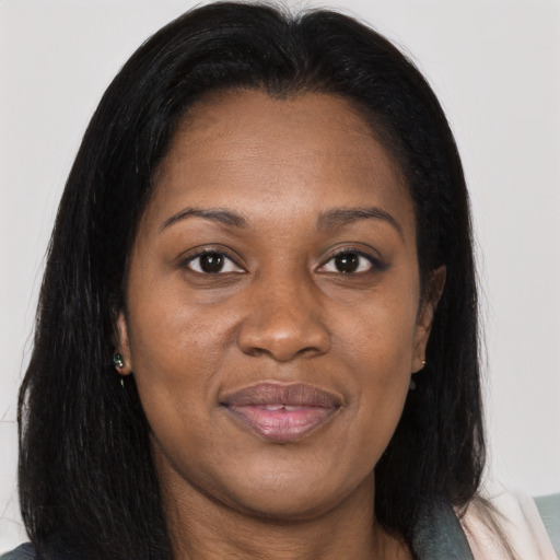 Joyful black young-adult female with long  brown hair and brown eyes