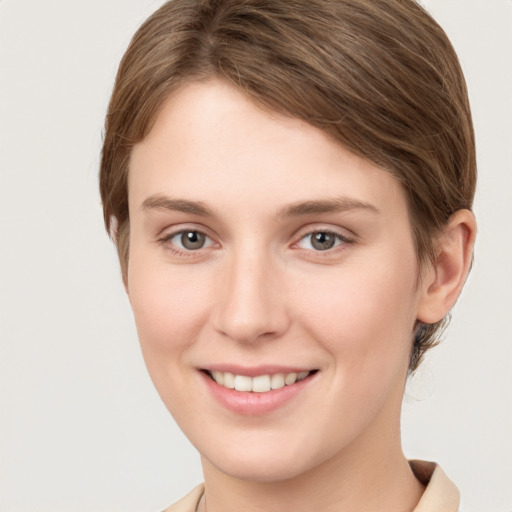 Joyful white young-adult female with short  brown hair and grey eyes