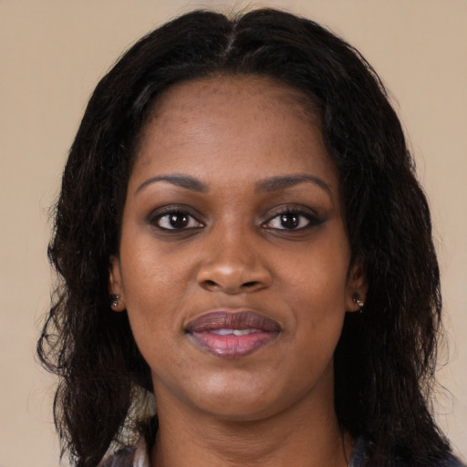 Joyful black young-adult female with long  black hair and brown eyes