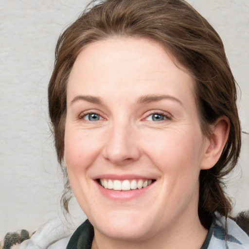 Joyful white young-adult female with medium  brown hair and blue eyes