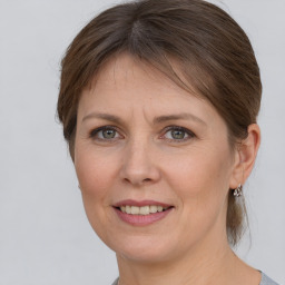 Joyful white adult female with medium  brown hair and grey eyes