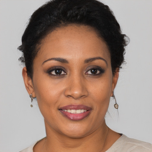 Joyful black young-adult female with short  black hair and brown eyes