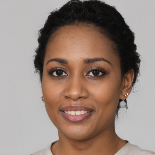 Joyful black young-adult female with short  black hair and brown eyes