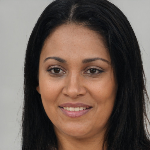 Joyful latino adult female with long  brown hair and brown eyes
