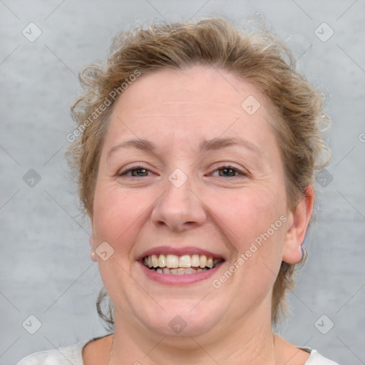 Joyful white adult female with medium  brown hair and blue eyes