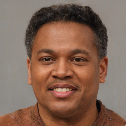 Joyful latino adult male with short  brown hair and brown eyes