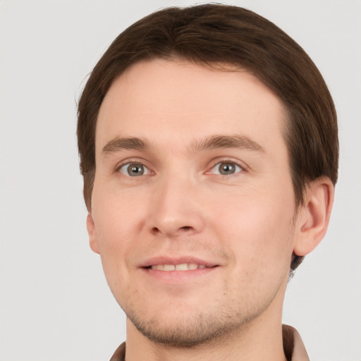 Joyful white young-adult male with short  brown hair and grey eyes