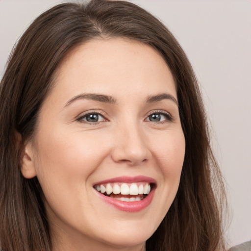 Joyful white young-adult female with long  brown hair and brown eyes