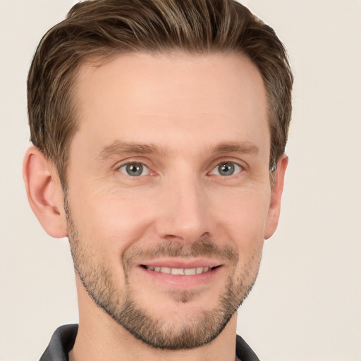 Joyful white young-adult male with short  brown hair and grey eyes