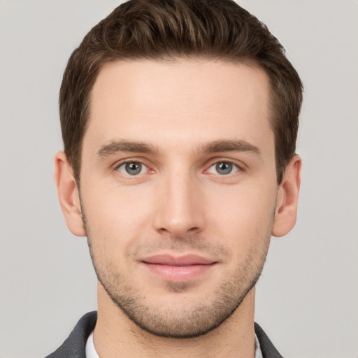 Joyful white young-adult male with short  brown hair and grey eyes