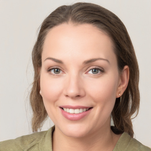 Joyful white young-adult female with medium  brown hair and grey eyes