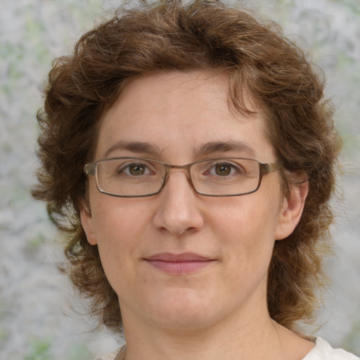 Joyful white adult female with medium  brown hair and green eyes