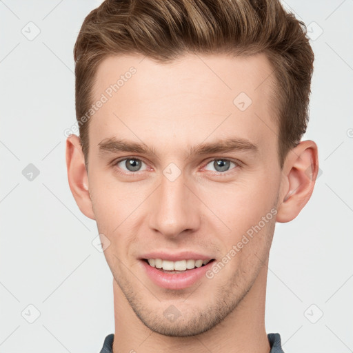 Joyful white young-adult male with short  brown hair and grey eyes