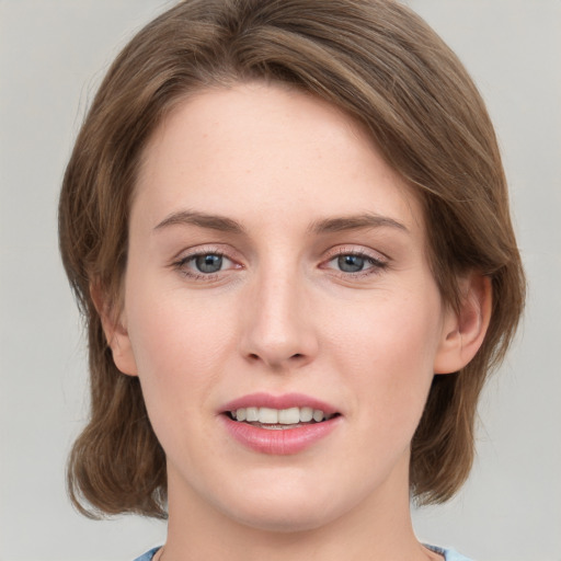 Joyful white young-adult female with medium  brown hair and grey eyes